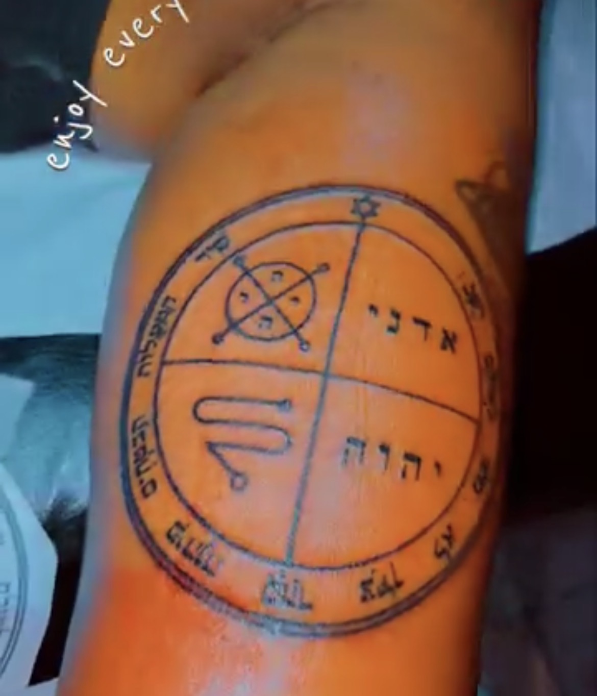 Original circular symbolic seal tattoo designed by Ainjel on a client’s upper arm